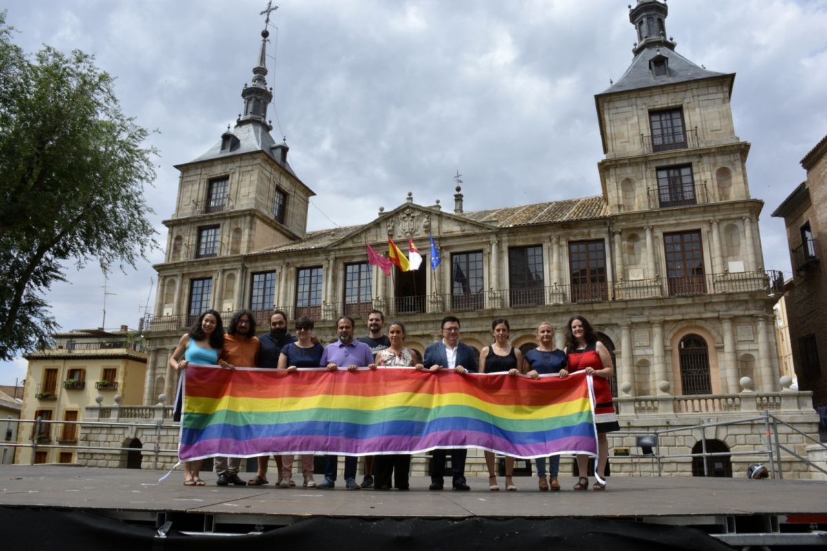 https://www.toledo.es/wp-content/uploads/2017/06/bandera_lgtbi-1200x800.jpg. La bandera arcoíris ondea por segundo año consecutivo en la fachada del Ayuntamiento en reconocimiento al colectivo LGTBI