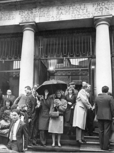 57 - 1986-01-07_La reina doña Sofía saluda al público desde las escaleras de acceso al hospital del Nuncio, sede de la Consejería de Economía_Foto Carvajal